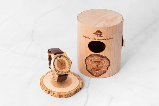 Handmade olivewood watch beside cremation urn, showcasing minimalist design and personalized engraving options.